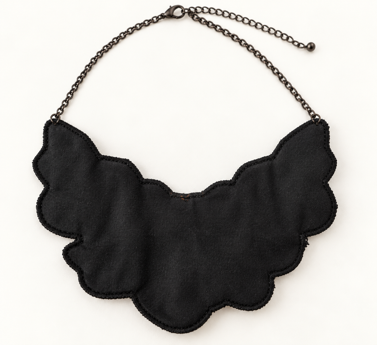 Back view of black textile bib statement necklace with adjustable dark-tone chain