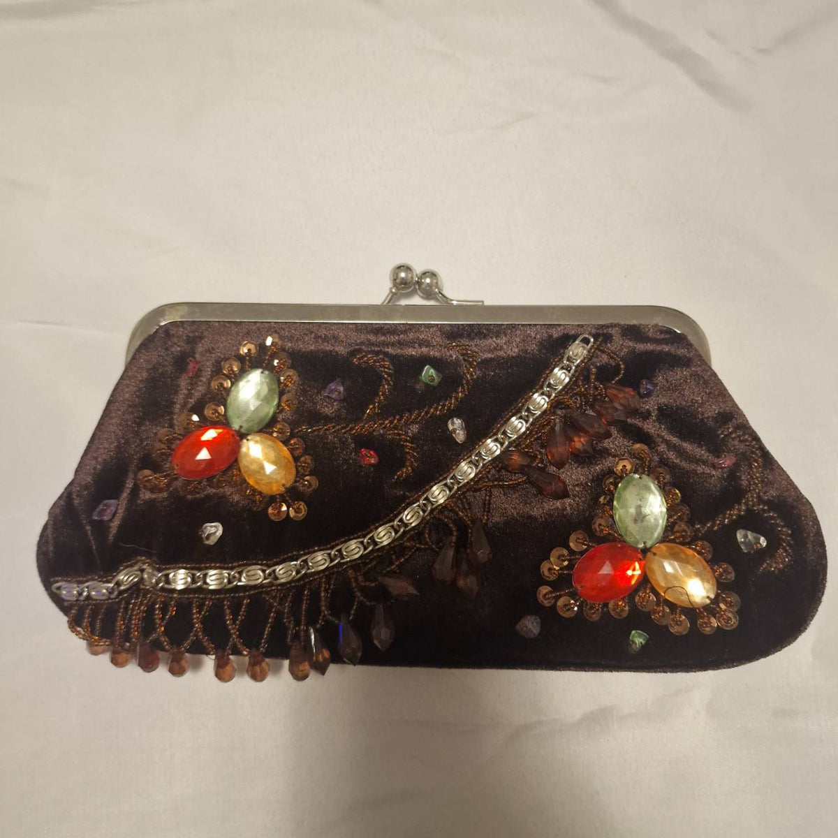 Brown velvet beaded evening bag shown straight on, with two jeweled floral clusters and decorative chain