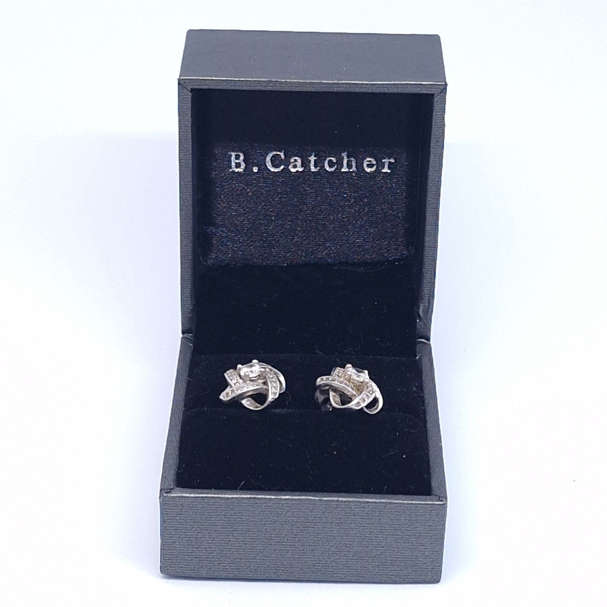 Open black box with a B.Catcher velvet pillow and a pair of knot earrings set in the slot