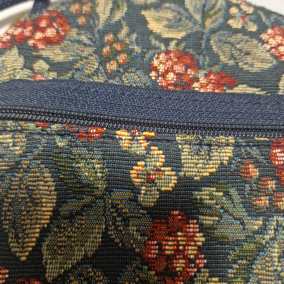 Close-up of the navy zip and the tapestry weave beside it