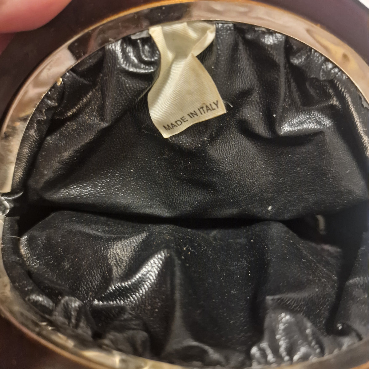 Black lining inside the evening bag with a white MADE IN ITALY label