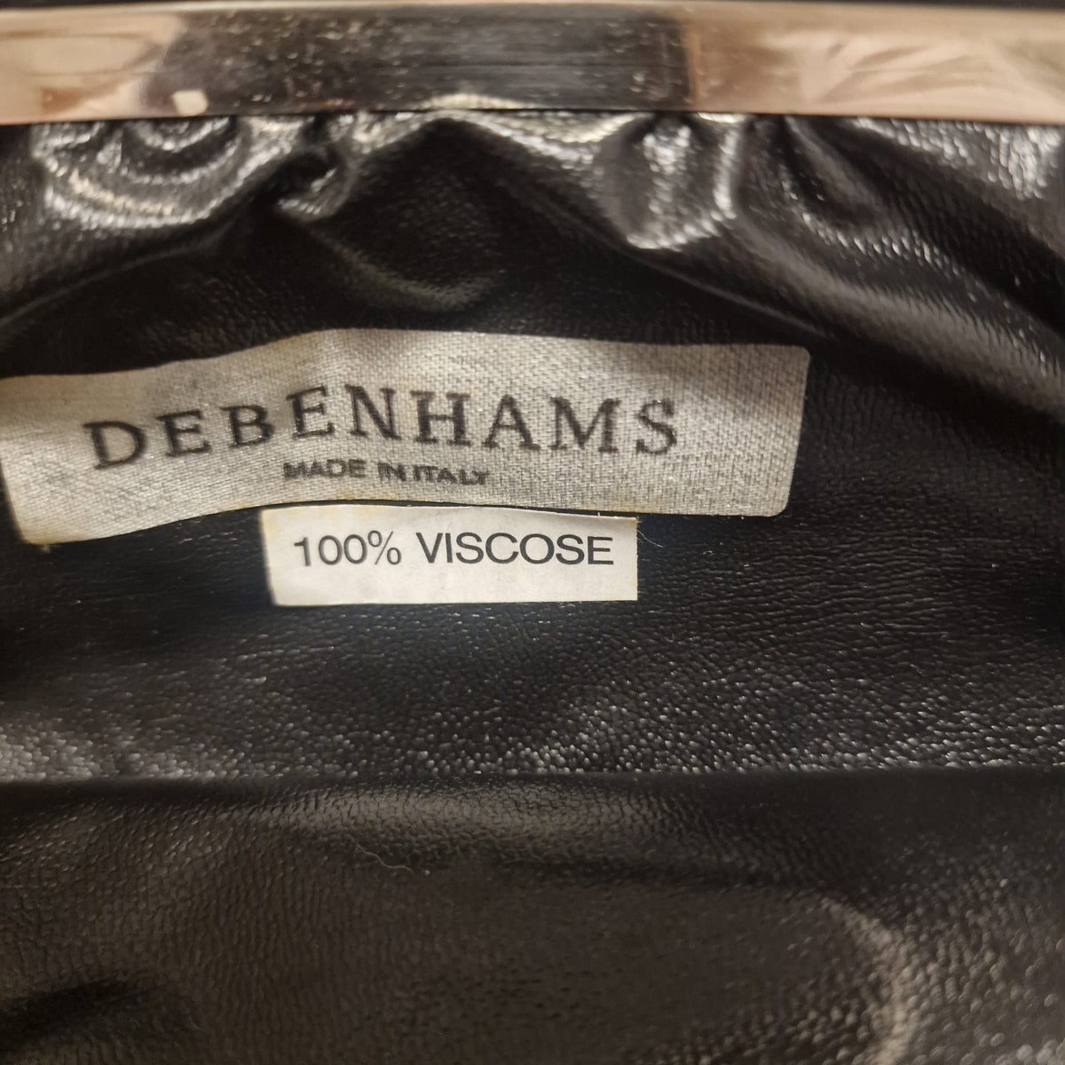 Inside label of the clutch reading Debenhams Made in Italy and 100% Viscose on glossy black lining