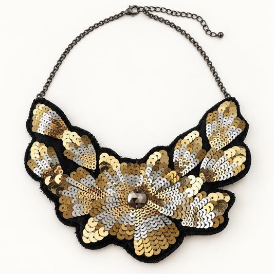 Women's black gold and silver sequin floral bib statement necklace on off-white background