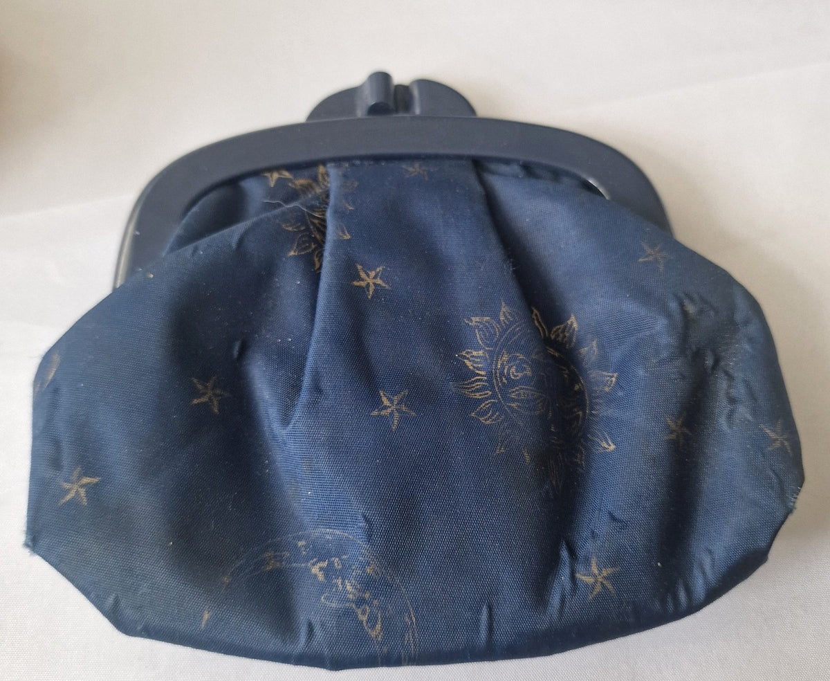 Second view of navy celestial fabric kiss-lock coin purse showing gathered shape and print