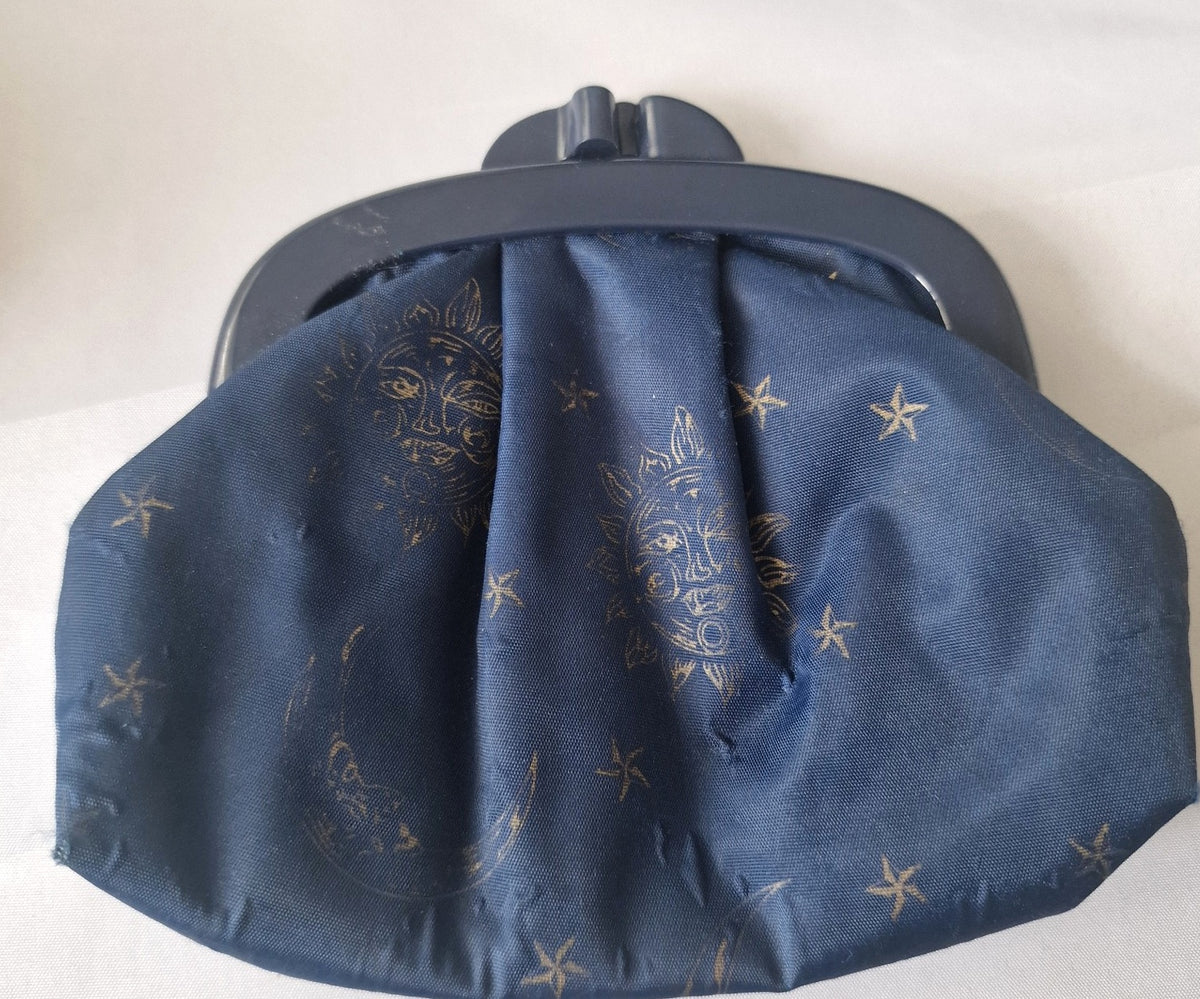 Navy blue celestial coin purse with gold sun moon and star print and dark kiss-lock frame