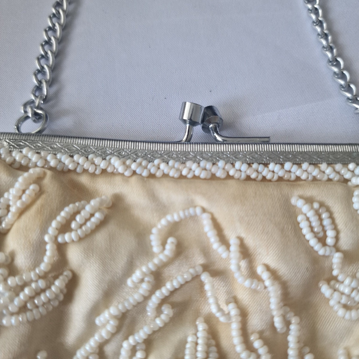 Silver-tone kiss-lock clasp and beaded trim detail