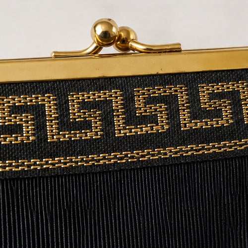 Vintage gold-tone kiss-lock and Greek key embroidery close-up