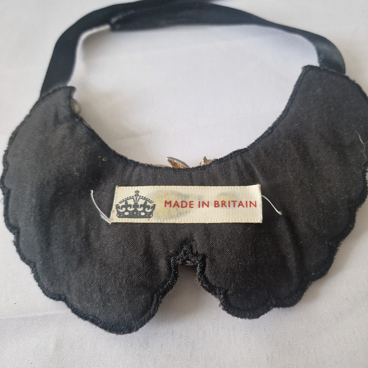 Back of vintage black bib necklace showing original Made in Britain crown label